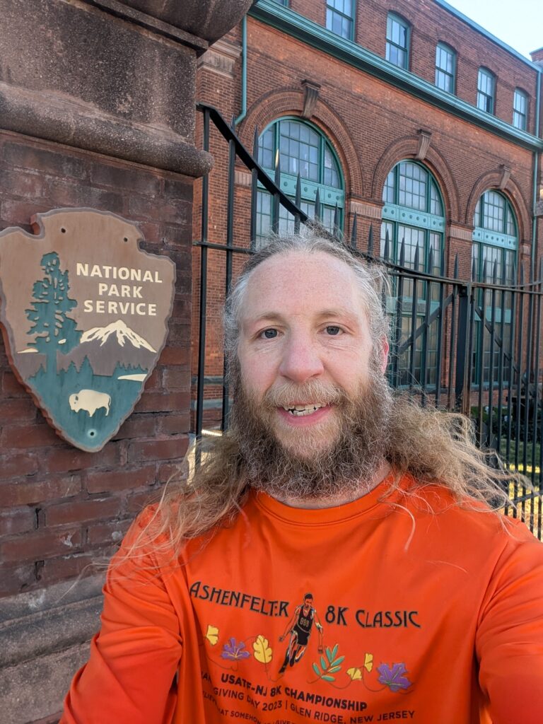 Brian in front of the Edison museum with a National Park Service sign behind him.